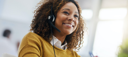 a customer support technician, smiling, wearing headset to answer phone calls